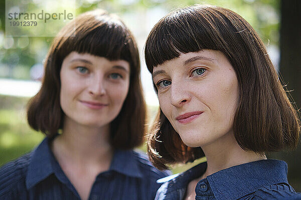 Lächelnde Zwillingsschwestern mit Haarpony