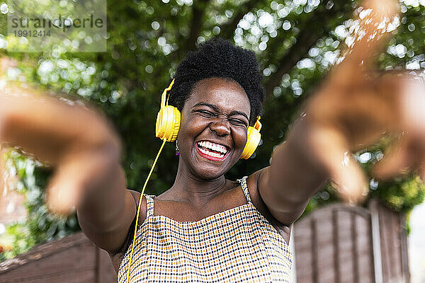 Fröhliche Frau  die über Kopfhörer Musik hört