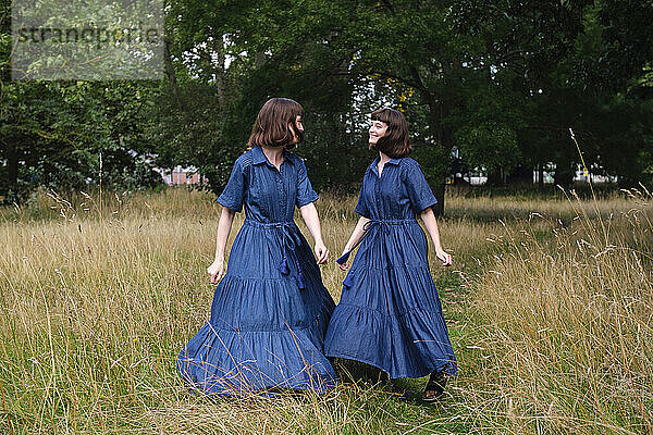 Glückliche Zwillingsschwestern genießen gemeinsam im Park