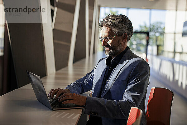 Geschäftsmann arbeitet am Laptop am Tisch