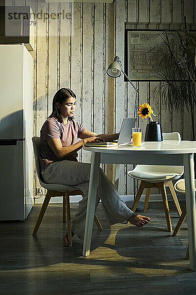 Junger Freiberufler arbeitet zu Hause am Laptop