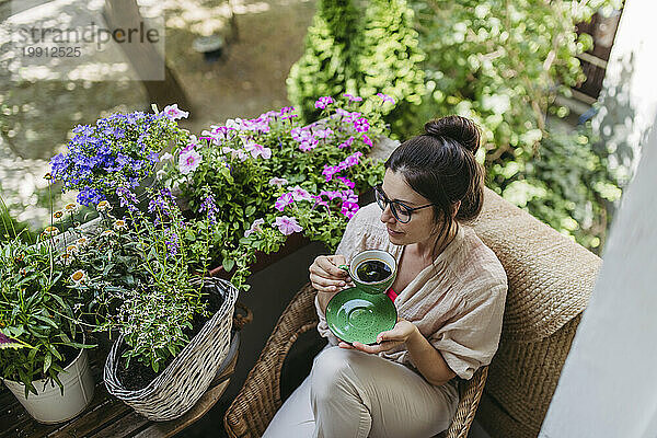 Woman enjoying her free time and a cup of coffee on the balcony