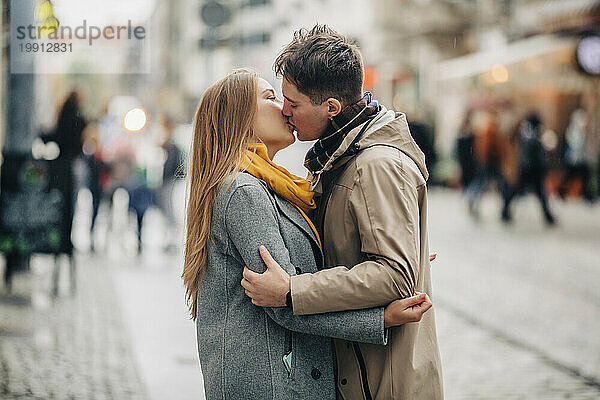 Zärtliches junges Paar  das sich auf der Straße küsst