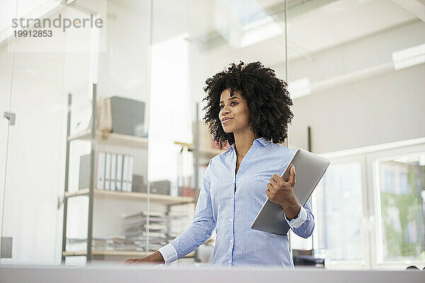 Businesswoman holding laptop at office