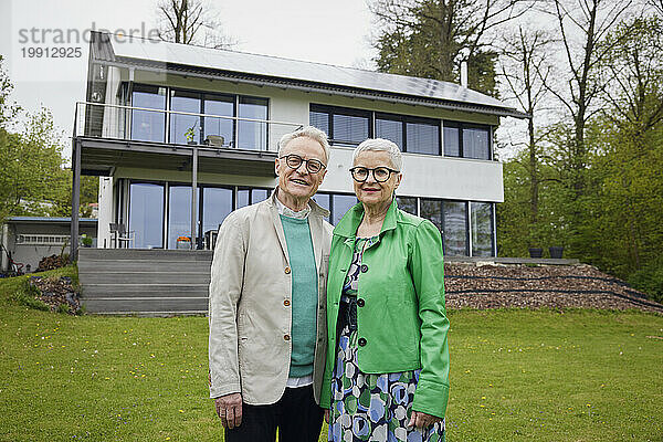 Portrait of senior couple in front of their home