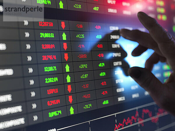 Hand des Händlers  der Börsendaten auf dem Bildschirm überprüft