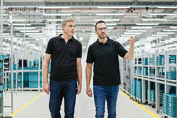 Zwei Kollegen schauen sich in einer Fabrik um
