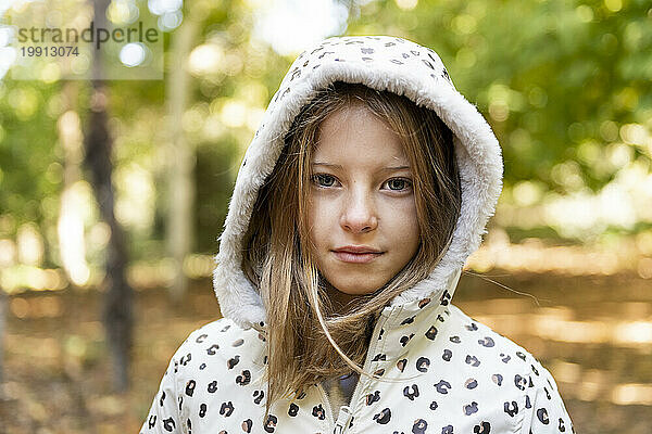 Lächelndes Mädchen mit Kapuzenshirt im Park