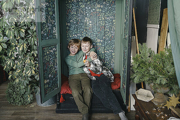Lächelnde Jungs sitzen zu Hause im Schrank