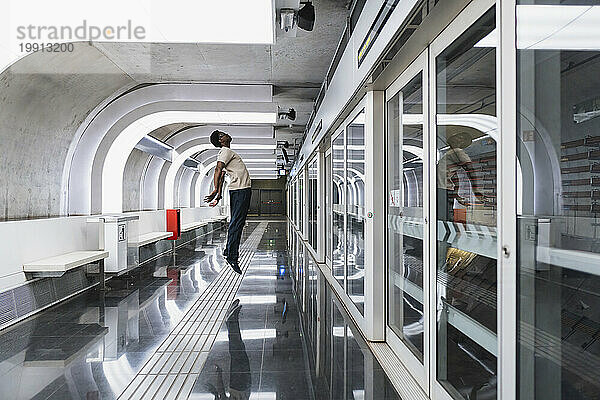 Mann mit futuristischer Brille steht an der U-Bahn-Station