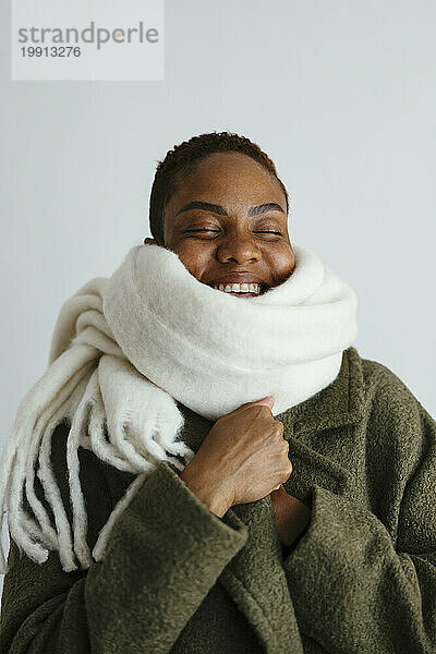 Happy woman wearing warm clothes against white background