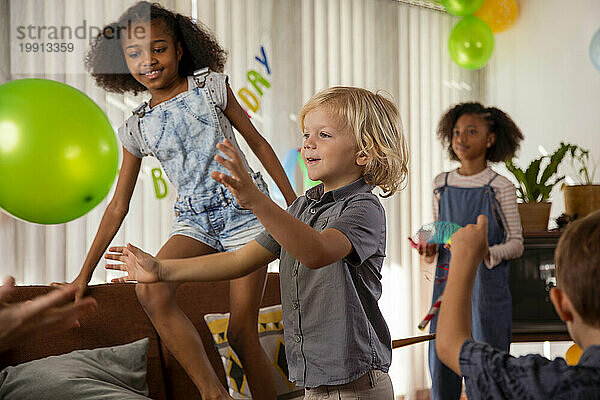 Glückliche Kinder  die zu Hause mit Luftballons spielen