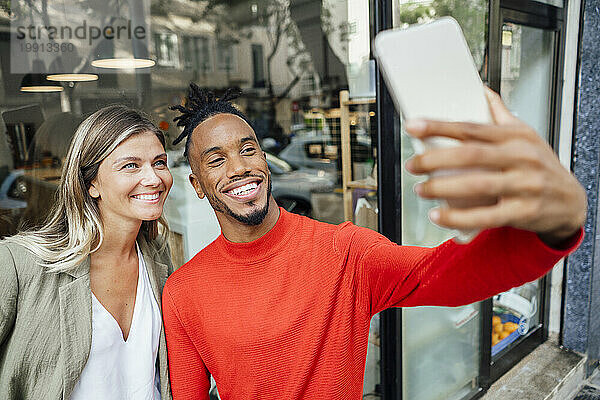 Geschäftsmann macht Selfie mit Kollegen über Tablet-PC vor Café