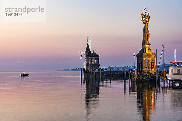 Deutschland  Baden-Württemberg  Konstanz  Hafen am Bodenseeufer im Morgengrauen mit Imperia-Statue im Vordergrund