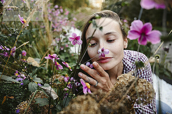 Frau riecht Blumen im Park