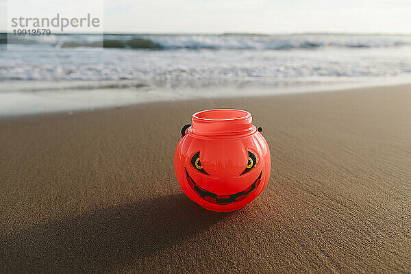 Halloween-Kürbisspielzeug auf Sand am Strand