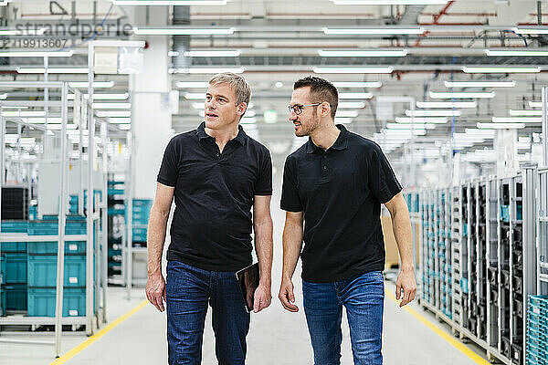 Zwei Kollegen schauen sich in einer Fabrik um