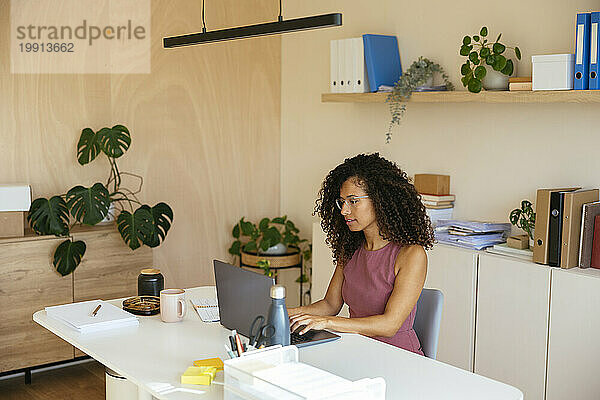 Geschäftsfrau arbeitet am Laptop am Schreibtisch im Büro