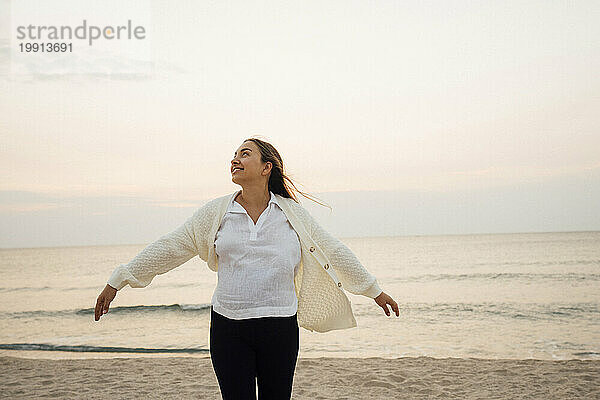 Glückliche junge schwangere Frau genießt den Strand