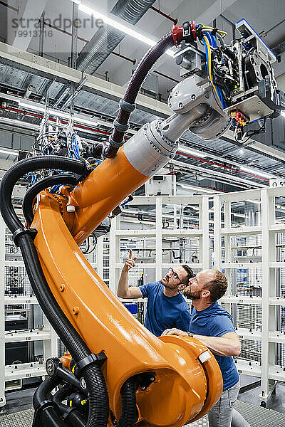 Zwei Techniker untersuchen Industrieroboter in einer Fabrik
