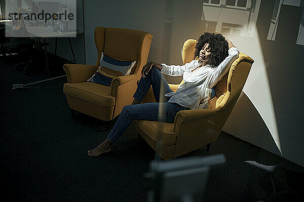 Geschäftsfrau entspannt sich im Sessel im Büro