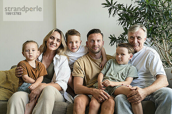 Lächelnder Großvater  Eltern und Kinder im Wohnzimmer zu Hause