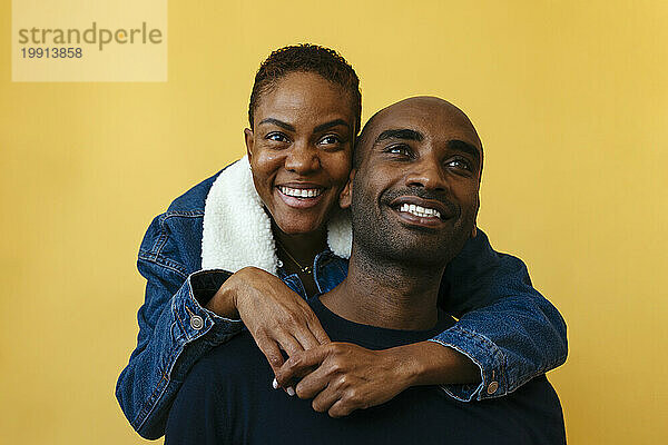Happy couple against yellow background