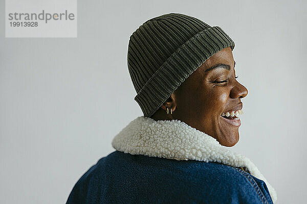 Happy woman wearing knit hat against white background