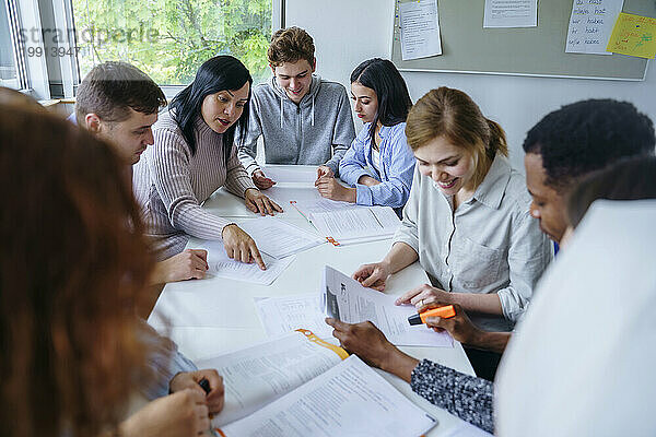 Multiethnische Studenten lernen gemeinsam am Schreibtisch im Schulungskurs