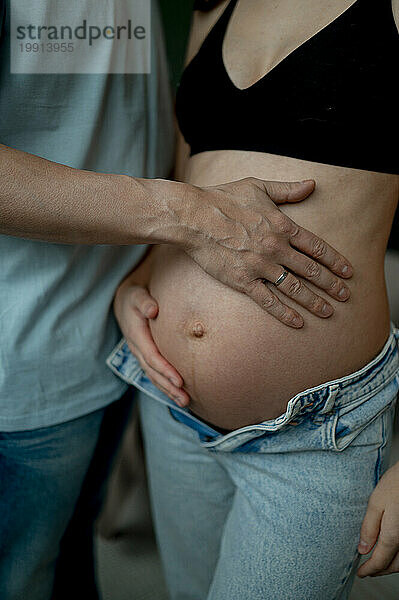 Mann berührt Bauch einer schwangeren Frau