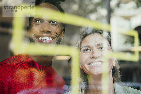 Multiracial business colleagues looking through glass window