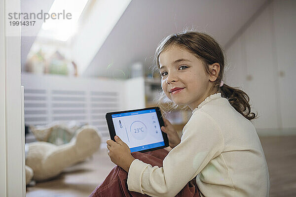 Lächelndes Mädchen hält Tablet-PC auf dem Dachboden