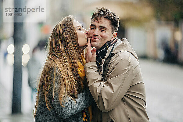 Freundin küsst Freund auf der Straße auf die Wange