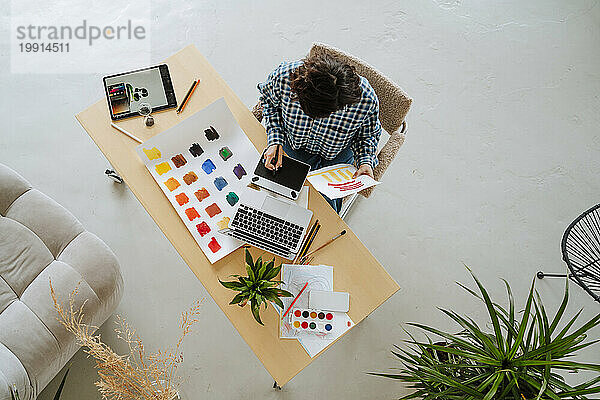 Young design illustrator working on wireless technologies at desk in office