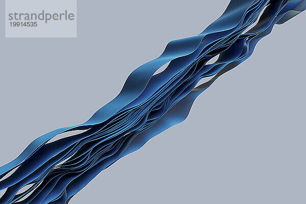 Schichten blauer Textilien  die in Wellenmuster vor grauem Hintergrund fließen