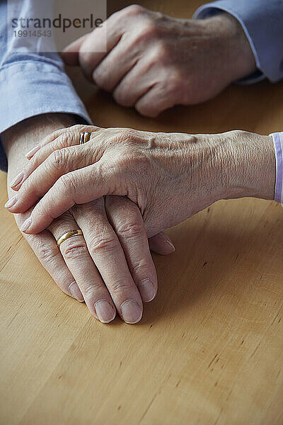 Nahaufnahme eines älteren Paares  das sich an den Händen hält