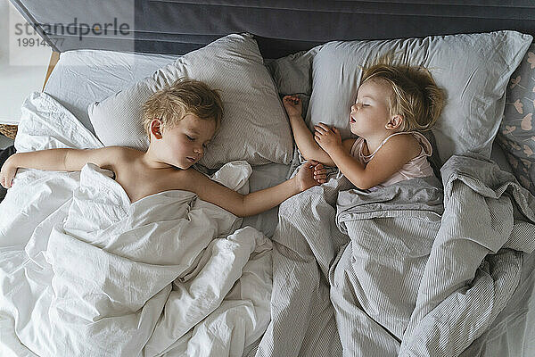 Children sleeping on bed at home