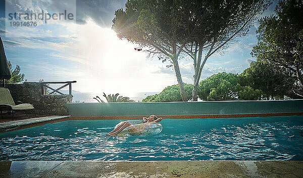 Mädchen mit aufblasbarem Schwimmring entspannt sich im Pool