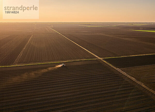 Serbia  Vojvodina Province  Aerial view of tractor sowing seeds at dusk