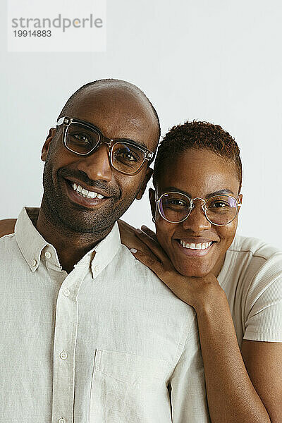 Happy couple wearing eyeglasses against white background