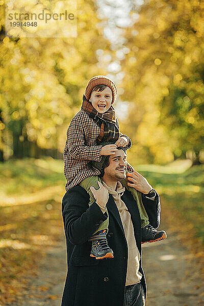 Glücklicher Vater und Sohn  die Spaß im Herbstpark haben