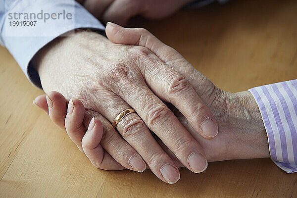 Nahaufnahme eines älteren Paares  das sich an den Händen hält
