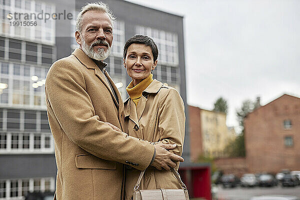Porträt eines älteren Paares  das sich bei einem Spaziergang in der Stadt umarmt