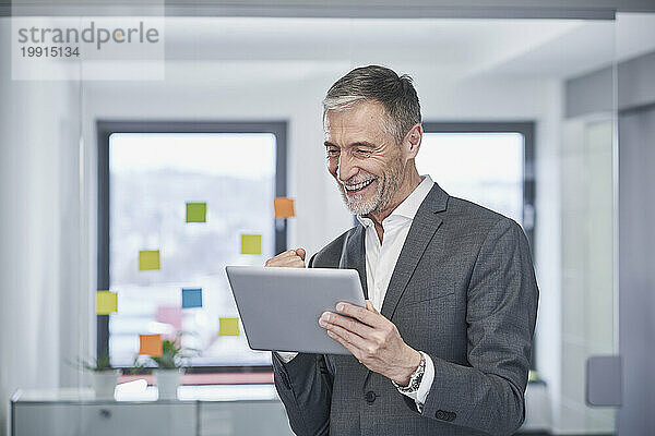 Successful senior businessman using tablet PC in office
