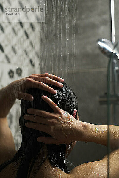 Frau wäscht Haare und nimmt zu Hause ein Bad