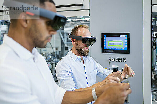 Zwei Techniker mit Augmented-Reality-Brille in einer Fabrik und gestikulieren