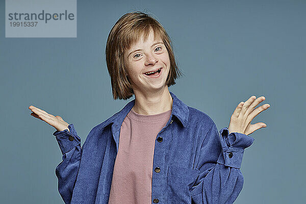Happy girl with Down syndrome against blue background
