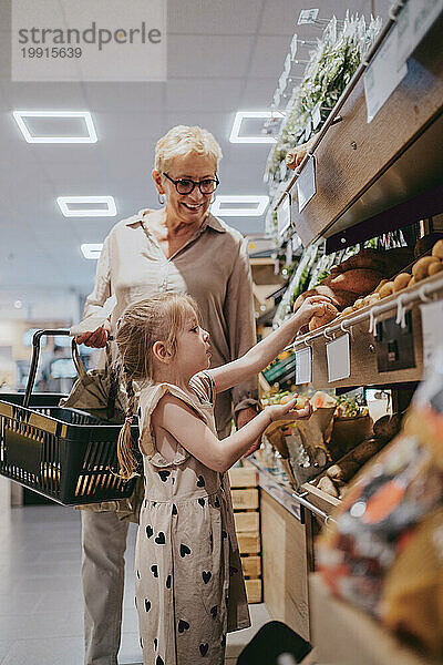 Enkelin kauft mit Seniorin im Supermarkt ein