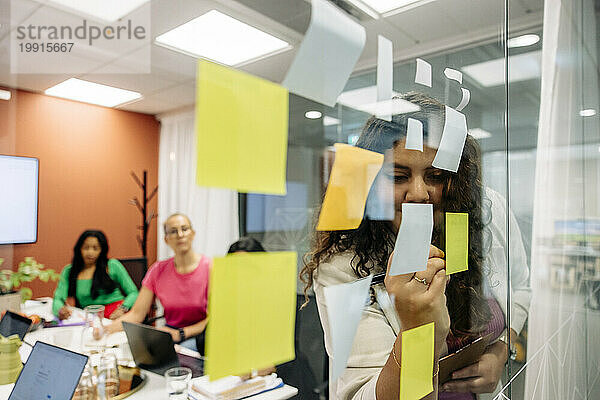 Junge Geschäftsfrau führt während eines Meetings im Büro eine Brainstorming-Sitzung mit Kollegen durch