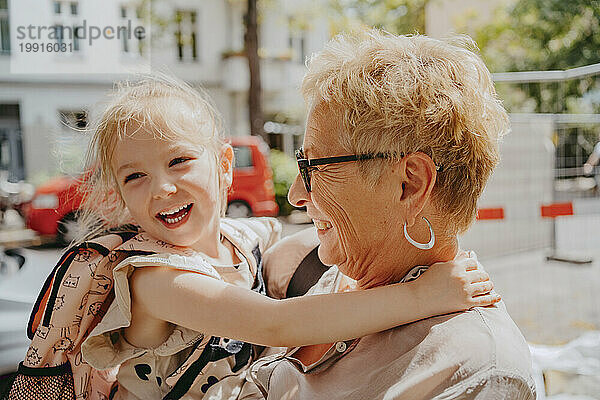 Glückliches Mädchen  das an einem sonnigen Tag mit Großmutter genießt